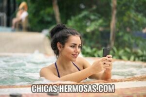 Cómo atraer mujeres: Chica al teléfono Cómo atraer mujeres: Chica bonita utilizando su teléfono celular para contactar personas nuevas.